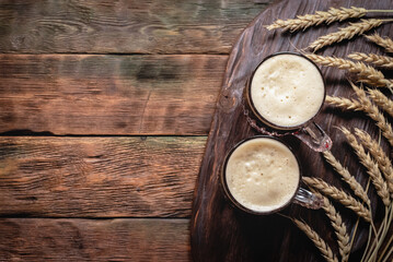 A two beer glass on the brown wooden table background with copy space.