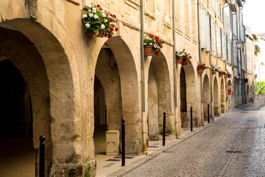 Stone buildings decorated with flower pots line the cobblestone steets in the village of Tarascon, France.