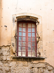 A closed window of a stone building  in the village of Beaucaire, France.