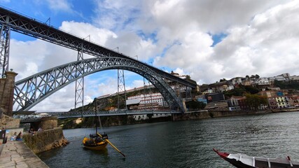 Bridge over the river called Dom Luis with boats and historic houses Portugal.