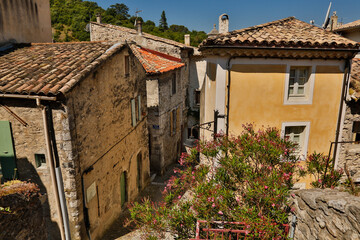Fototapeta na wymiar Stone buildings and a sidewalk in Viviers. Viviers is a commune in the department of Ardèche in southern France. It is a small walled city situated on the bank of the Rhône River.