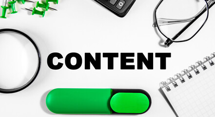 Business concept. On the white table is a calculator, magnifer, green markers, glasses, pins and a notebook with the inscription content - Business Coaching