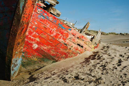 Shipwreck boat buried by sand on a deserted beach