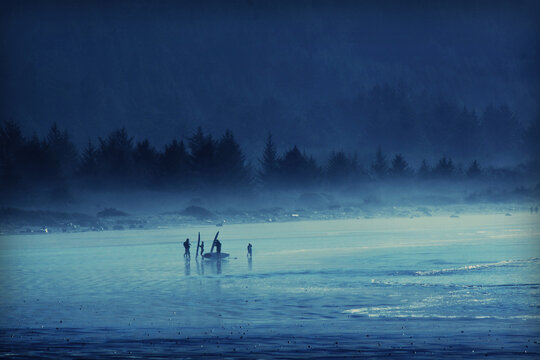 Surfers in the fog on the beach