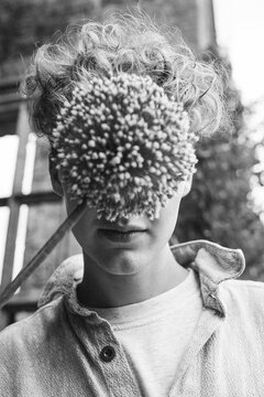 Plant covering face of young male model