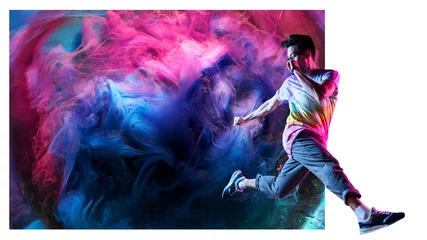 Schilderijen op glas Professional break dancer posing in motion, practicing modern hip-hop dance against the background of abstract colorful smoke © amixstudio