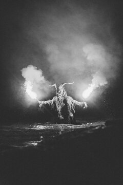 krampus with bengal light coming out of a water