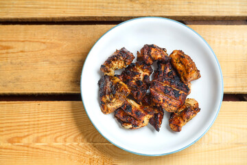 Grilled chicken in pad thai sauce on a light plate.