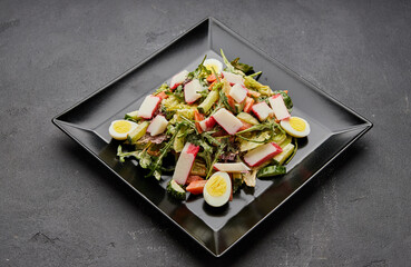 Crab stick salad with fresh vegetable and eggs.