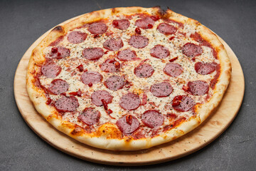 Delicious Italian Pizza pepperoni with mozzarella cheese and salami on dark background
