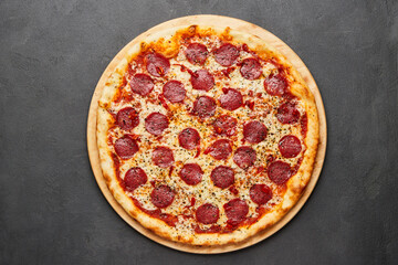 Delicious Italian Pizza pepperoni with mozzarella cheese and salami on dark background