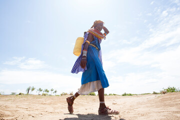 Samburu women collecting water from well in desert. Kenya.