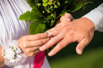 The bride places the ring on the groom's hand. Photo closeup. Wedding details. 