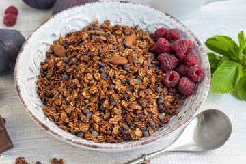 Homemade granola with chocolate and nuts on a light background. Vegetarian dish. Healthy breakfast.