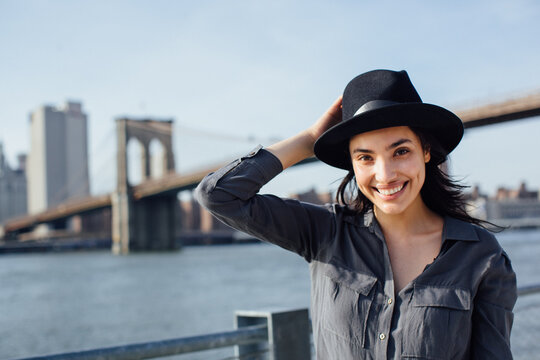 Portrait of smiling beautiful woman looking at the camera with the Manhattan Bridge on the background
