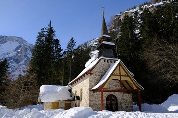 Beautiful winter view with
snow-covered stone church at the foot of the mountains on lake Lago di Braies, Alta Pusteria, Dolomites, Italy