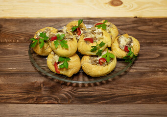 Profiteroles stuffed with cream cheese, onions and mushrooms close up on wooden background. Selective focus