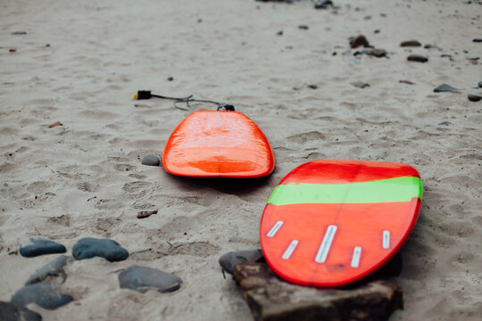 Two surfboards laying in the sand
