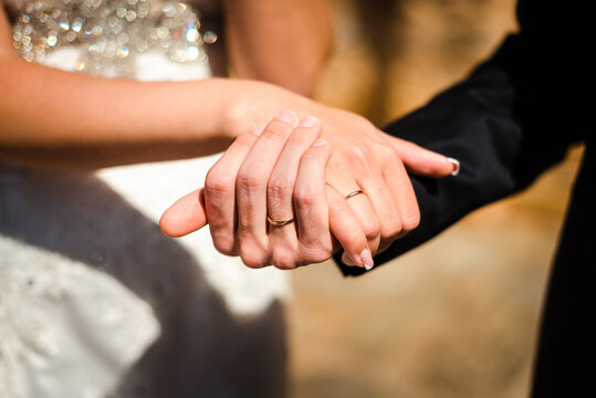 Close up picture of the bride's and groom's hands with wedding rings 