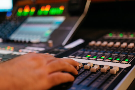 Sound engineer's hand on mixer board