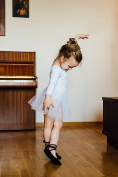 Young ballerina girl dancing in the house