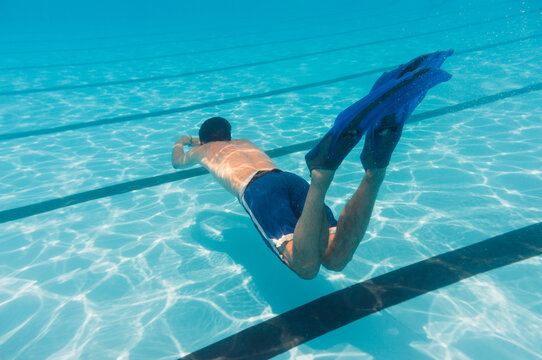 Young Caucasian man diving in swimming pool