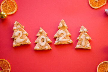 Gingerbread cookies. 2021 numbers. New year greeting card. Top view. Vivid Red background. Dried oranges. Zero waste Christmas gift 
