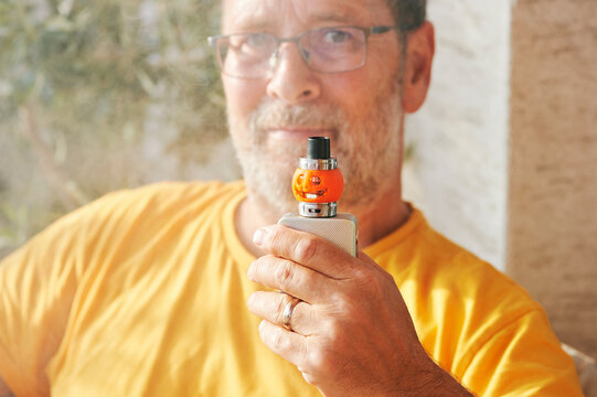Man holding vape with Halloween pampkin decoration
