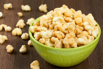 A Bowl Of Tasty Caramelized Popcorn; On Wooden Background.