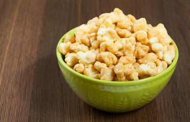A Bowl Of Tasty Caramelized Popcorn; On Wooden Background.