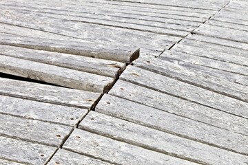 The surface of a wooden structure damaged by severe weather conditions. Old wooden planks surface texture. Surface made of weathered planks. Damaged Wooden surface made of antique boards.