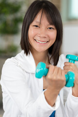 girl exercising with dumbbells indoors