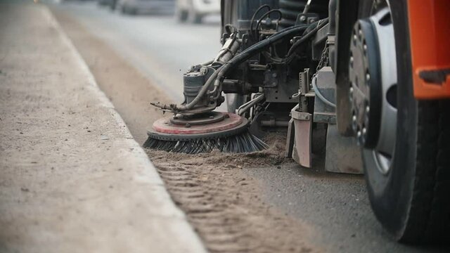 Big industrial machine levels concrete dust with a sweeper on the side of the road