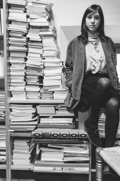 Young Female Student Sitting Beside a lots of Books