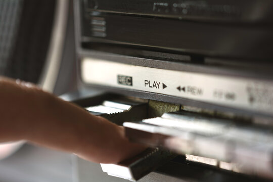 Hand pressing the play button on a boom box