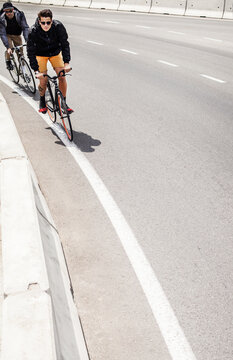 2 urban fixed gear bike cyclist racing on city streets.