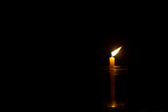 lit candle in the dark
