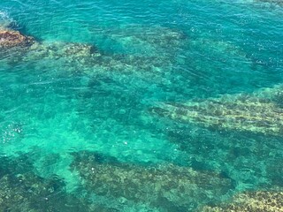 Fototapeta na wymiar Beautiful aquamarine color of sea water. Adriatic sea background. Blue freshness. Underwater world. Stones and seaweed. Turquoise surface of waters. Amazing marine.