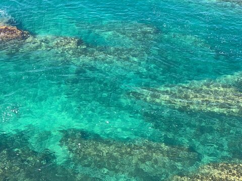 Beautiful aquamarine color of sea water. Adriatic sea background. Blue freshness. Underwater world. Stones and seaweed. Turquoise surface of waters. Amazing marine.