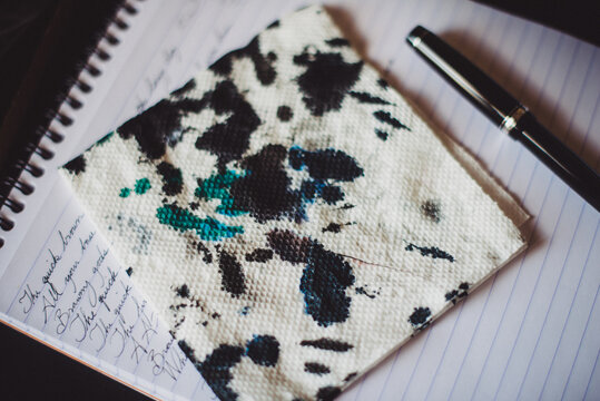 Ink blots on napkin, fountain pen and notepad