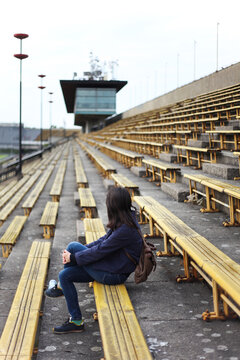 Woman sitting on an old stadion