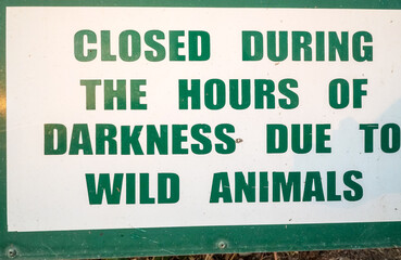 sign with the text closed during the hours of darkness due to wild animals in South Africa concept safari in Africa