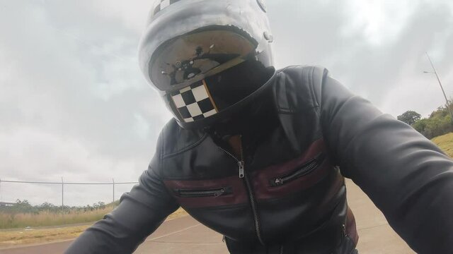 Primer plano de Motociclista conduciendo con casco en dia nublado