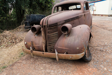 old rusty car, wreck, jalopy standing in the street in Pilgrims Rest, South Africa