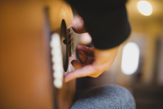 Hand strumming strings on guitar