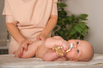 Massage the newborn close up. Female hands massage baby, newborn care concept, massage of abdominal colic, teething.