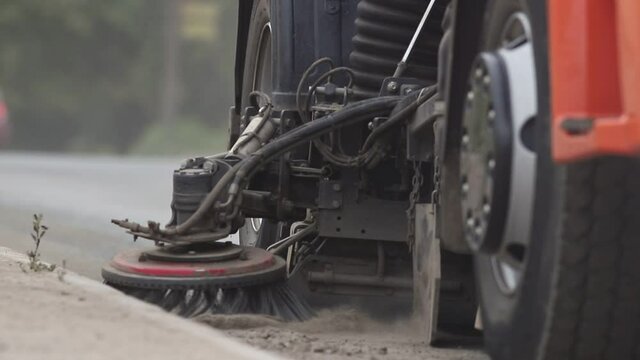 Industrial machine clears the asphalt out of dust with a sweeper