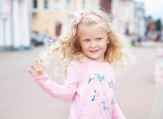 little girl with curly blonde hair on a walk, summer day