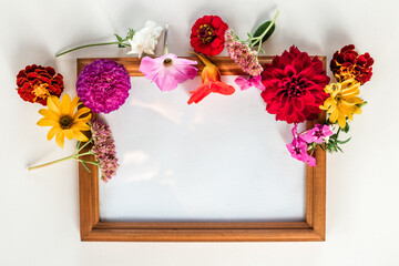 frame with bouquet of flowers on white background. Flat lay, top view, copy space