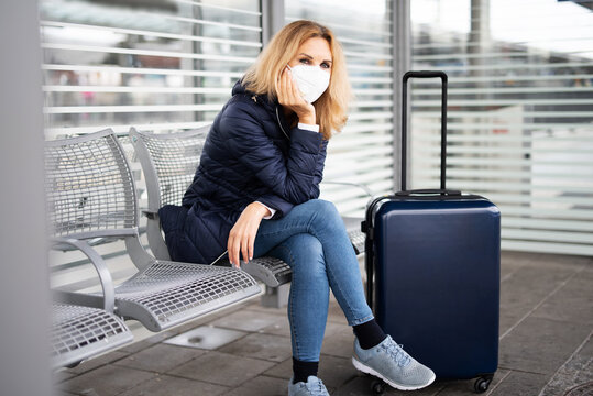 Eine Frau mit Maske wartet am Bahnhof, Maskenpflicht in der Öffentlichkeit 